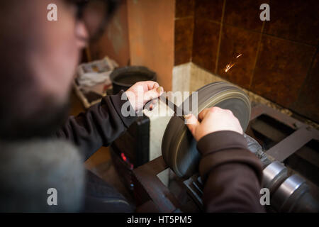 Aufnahme eines Mannes Hand eine Schere schärfen hautnah. Stockfoto