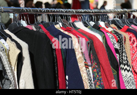 gebrauchte Kleidung aufgehängt Aufhänger für Verkauf in Flohmarkt Stockfoto