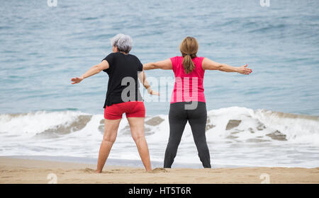 Ältere Frauen am Strand täglich Dehnung halten Passungsklasse in Spanien Stockfoto