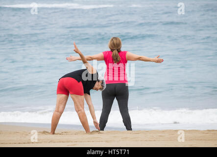 Ältere Frauen am Strand täglich Dehnung halten Passungsklasse in Spanien Stockfoto