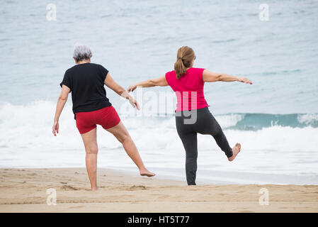 Ältere Frauen am Strand täglich Dehnung halten Passungsklasse in Spanien Stockfoto