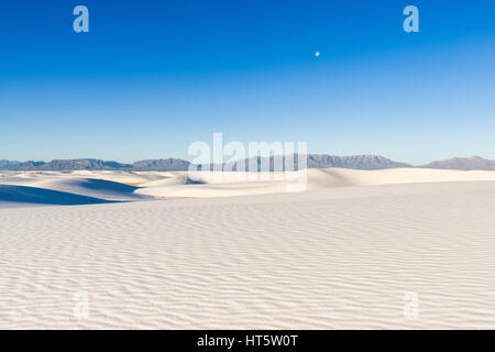 Sanddünen und Erosion Formationen mit Bergen und Mond im Hintergrund, im Nachmittag Licht, White Sands National Monument, New Mexico Stockfoto