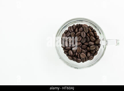 Bio Kaffee Bohnen mit dem dunklen geröstet in das klare Glas auf die weiße Leinwand. Stockfoto