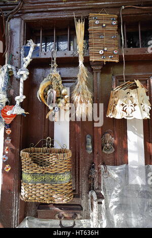 Alte Holztür viel Nazar Boncugu-blaue Perle Auge Amulette und Sonstiges Wicker-Holz-Stroh hängen geprägt. Straße im alten sind Stockfoto