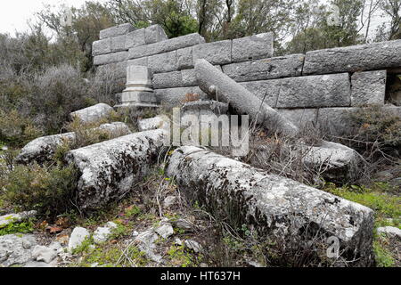 Gefallenen Spalten-Reste der Mauern-Gebäude im Bereich der Agora im grauen steinernen Quadern in der Nähe von dem oberen Tor der Stadt in der aktuellen Güllük Dagi-Termes Stockfoto