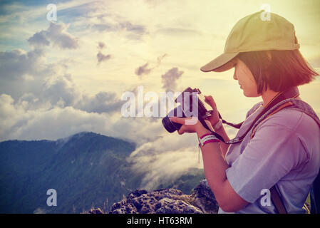 Vintage-Stil Wanderer Teens Mädchen tragen Kappen Digitalkamera Foto betrachten ist landschaftlich natürliche des Sierra und des Himmels während des Sonnenuntergangs am Berg Stockfoto