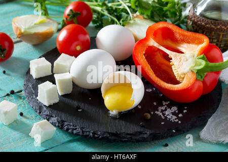 Frische Bio-Zutaten für die Zubereitung von Ei Omelett gefüllt mit Tomaten und Käse Sulguni. Konzept einer gesunden Ernährung oder Detox Diät Stockfoto