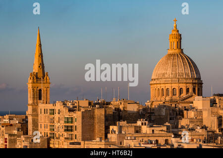 Ein Kirchturm und Dome in Valletta, Malta bei Sonnenuntergang Stockfoto