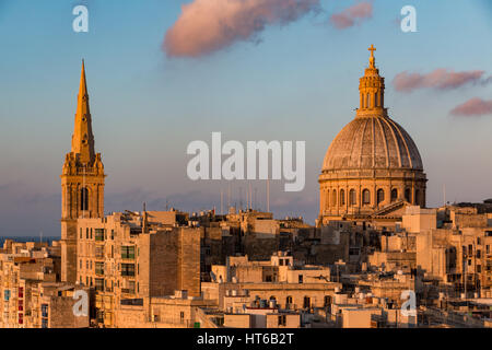 Ein Kirchturm und Dome in Valletta, Malta bei Sonnenuntergang Stockfoto