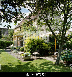 Garten mit Stühlen und Sonnenschirm. Stockfoto