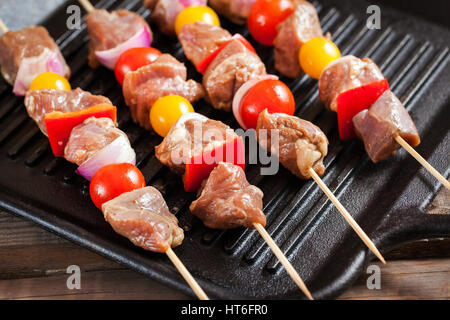 Rohe Türkei Fleischspieße mit Cherry-Tomaten, Paprika und Zwiebel auf Grill vor dem Kochen Stockfoto