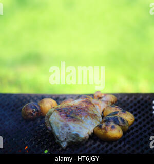 Backen Lamm, Bein und Kartoffeln auf Grill im freien Stockfoto