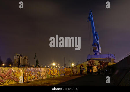 Alten Dock in der ehemaligen Hafen von Gent, lokal bekannt als "Grindbakken", mit Graffiti und blue Crane, jetzt als einen öffentlichen Treffpunkt genutzt. Stockfoto