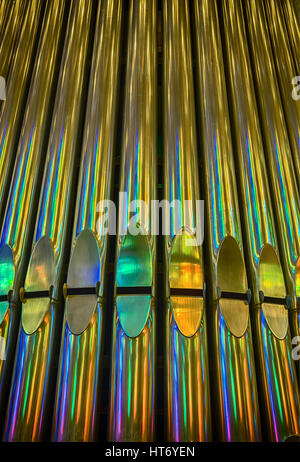 Die Rohre auf eine volle Orgel Leuchten mit Messing und helle, farbige Reflexe aus einer Reihe von bunten Glasfenstern. Stockfoto