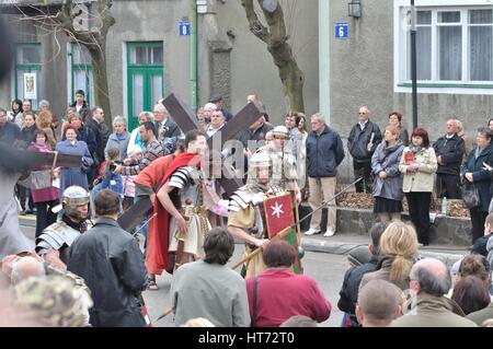 Jesus trägt sein Kreuz auf dem Weg zu seiner Kreuzigung, während das Straßentheater Geheimnis der Passion Stockfoto