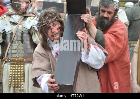 Jesus wird von Simon geholfen, sein Kreuz, während das Straßentheater Geheimnis der Passion durchzuführen. Stockfoto