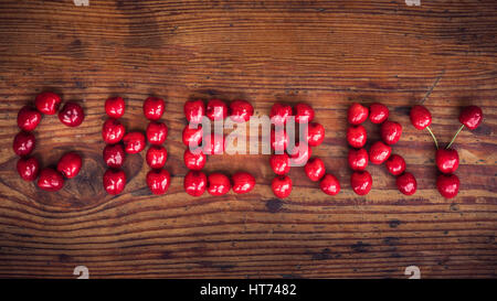 Reife Bio homegrown Kirschen auf hölzernen Hintergrund, Cherry text Stockfoto