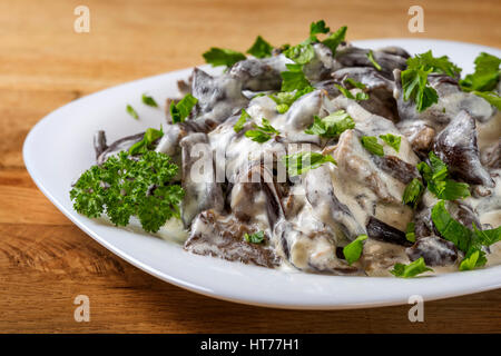 Rumänische Lebensmittel - Pilze mit Sauerrahm und Petersilie auf Platte Stockfoto