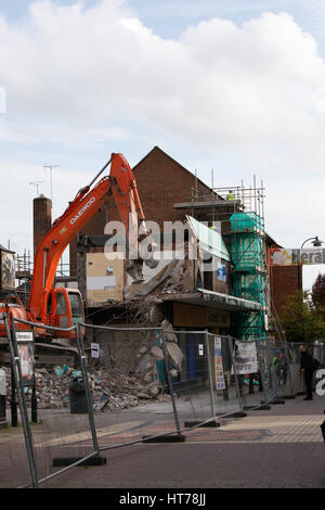 Schwere Maschinen bei der Arbeit auf ein Abriss-Baustelle. Abriss der alten Läden Stockfoto