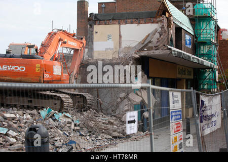 Schwere Maschinen bei der Arbeit auf ein Abriss-Baustelle. Abriss der alten Läden Stockfoto