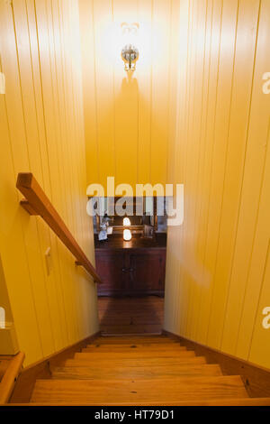 Gelb beleuchtet pinewood Treppe im alten Haus 1722 Interieur. Stockfoto