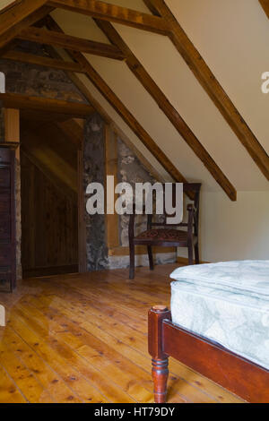 Hauptschlafzimmer mit spärlicher Einrichtung 1826 Canadiana fieldstone altes Haus innen renoviert.. Stockfoto