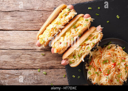 Hot Dog mit Sauerkraut und Senf hautnah auf dem Tisch. horizontale Ansicht von oben Stockfoto