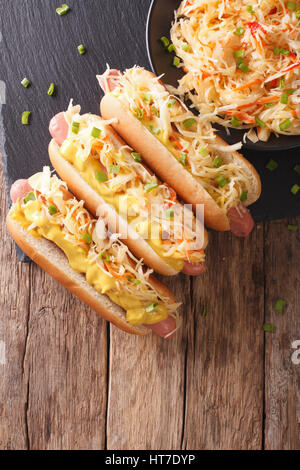 Hot Dog mit Sauerkraut und Senf hautnah auf dem Tisch. Vertikale Ansicht von oben Stockfoto