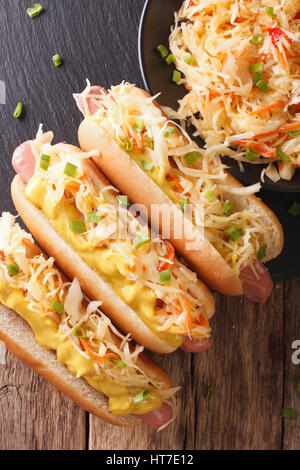 Leckere Sandwich mit Wurst, Sauerkraut und Senf hautnah auf dem Tisch. Vertikale Ansicht von oben Stockfoto