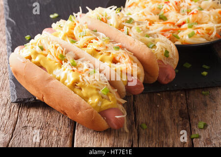 Leckere Sandwich mit Wurst, Sauerkraut und Senf hautnah auf dem Tisch. horizontale Stockfoto