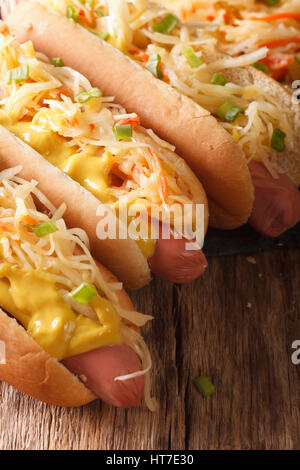 Sandwich mit Wurst, Sauerkraut und Senf hautnah auf dem Tisch. vertikale Stockfoto