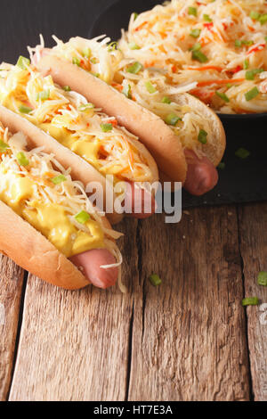 Hot Dog mit Sauerkraut und Senf hautnah auf dem Tisch. vertikale Stockfoto