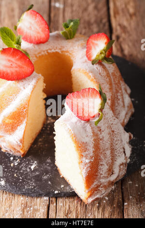 Hausgemachtes Vanille-Gugelhupf mit Minze und Erdbeeren Nahaufnahme auf dem Tisch. vertikale Stockfoto