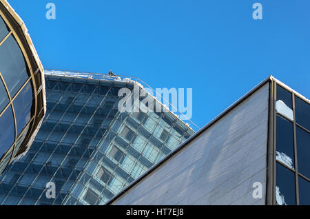 Element des modernen Bauens. Die Glasfassade des Winters vor einem blauen Himmel. Architektonischen Hintergrund Stockfoto