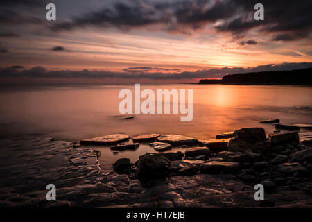 Sonnenuntergang über Kimmeridge Bay Dorset. Kimmeridge ist ein kleines Dorf auf der Isle of Purbeck, einer Halbinsel an der englischen Kanalküste in Dorset. Stockfoto