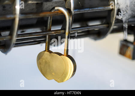 Rosa Vorhängeschloss in der Form von Herzen an modernen Stahl Chrom Reling Stockfoto