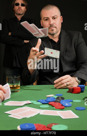 Foto eines Pokerspielers in seine Karten zu werfen. Stockfoto