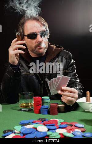 Foto von einem Mann mit dem Pokern und raucht eine Zigarre. Spielkarten sind geändert worden, um generisch sein. Stockfoto