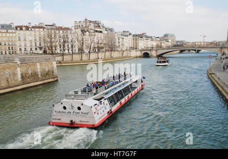 Ein Ausflugsschiff Kreuzfahrten in Richtung Pont Saint-Michel auf der Seine in Paris, Frankreich. Viele Ausflüge finden statt am Fluss jeden Tag. Stockfoto