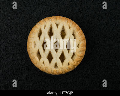 Gitter gekrönt individuelle Bramley Apfelkuchen auf schwarzem Hintergrund Stockfoto