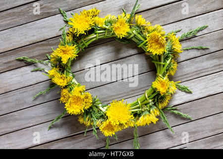 Frühling Hintergrund. Kranz aus Löwenzahn frische Blumen auf einem hölzernen Hintergrund. Kopieren Sie Raum. Stockfoto