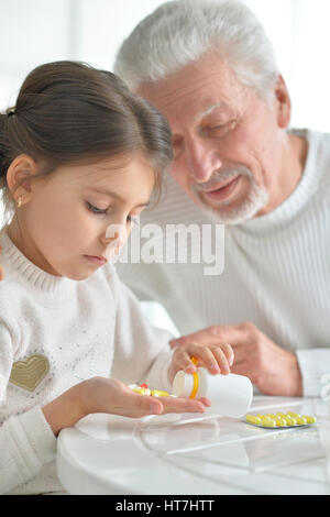 Enkelin kümmert sich um einen kranken Großvater Stockfoto