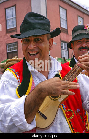 Porträt von ein lächelnder Mann im traditionellen Gewand spielt Ukulele Stockfoto