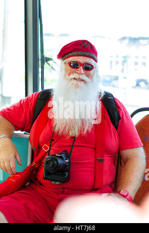 Helsinki, Finnland - 5. August 2012: Amerikanische Weihnachtsmann in rot Sommer Anzug mit Fotokamera in Straßenbahn Auto sitzen. Stilvolles Interieur Straßenbahn mit se. Stockfoto