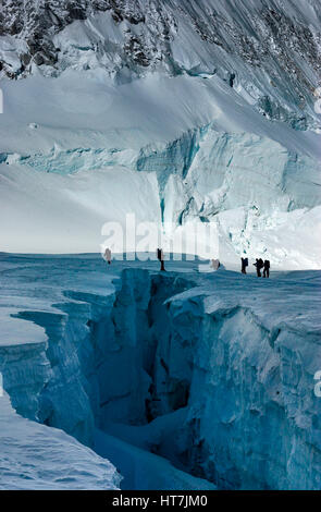 Kletterer überqueren eine klaffende Gletscherspalte im westlichen Cwm am Mount Everest, Nepal Stockfoto