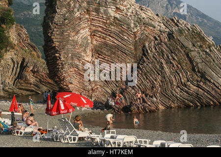 Becici, Budva, Montenegro, 22. Mai 2009: Menschen am Strand von Becici und einer felsigen Klippe im Hintergrund. Stockfoto