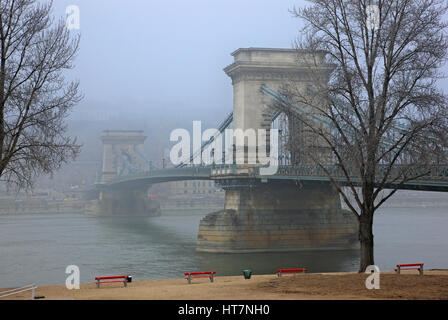 Die Donau und Széchenyi Kettenbrücke halb verborgen im Nebel. Budapest, Ungarn. Foto von der Seite von Pest. Stockfoto