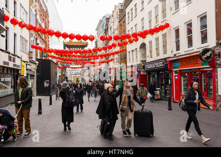 Touristen in der Wardour Street dekoriert mit chinesischen Laternen für das chinesische Neujahrsfest. Chinatown, London, UK Stockfoto