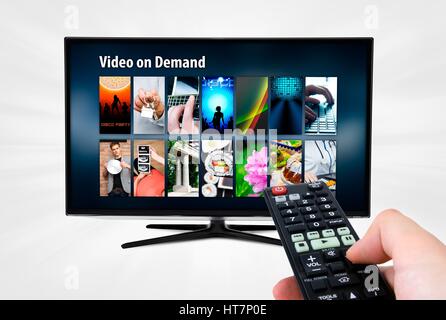 Als Video on Demand VOD-Dienst auf smart TV. Fernbedienung in der Hand. Stockfoto