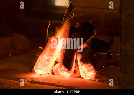 Aktivierte Holzkohle brennen im Inneren eines Ofens in Vorbereitung zum Grillen von Fleisch. Stockfoto